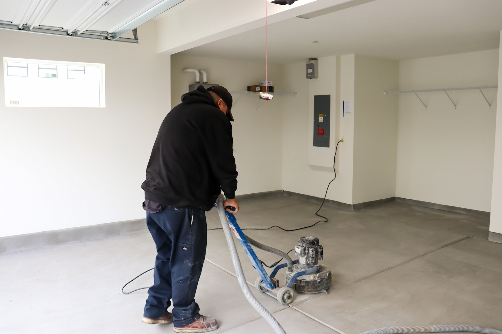 machine grinding concrete floor before garage floor coating installation