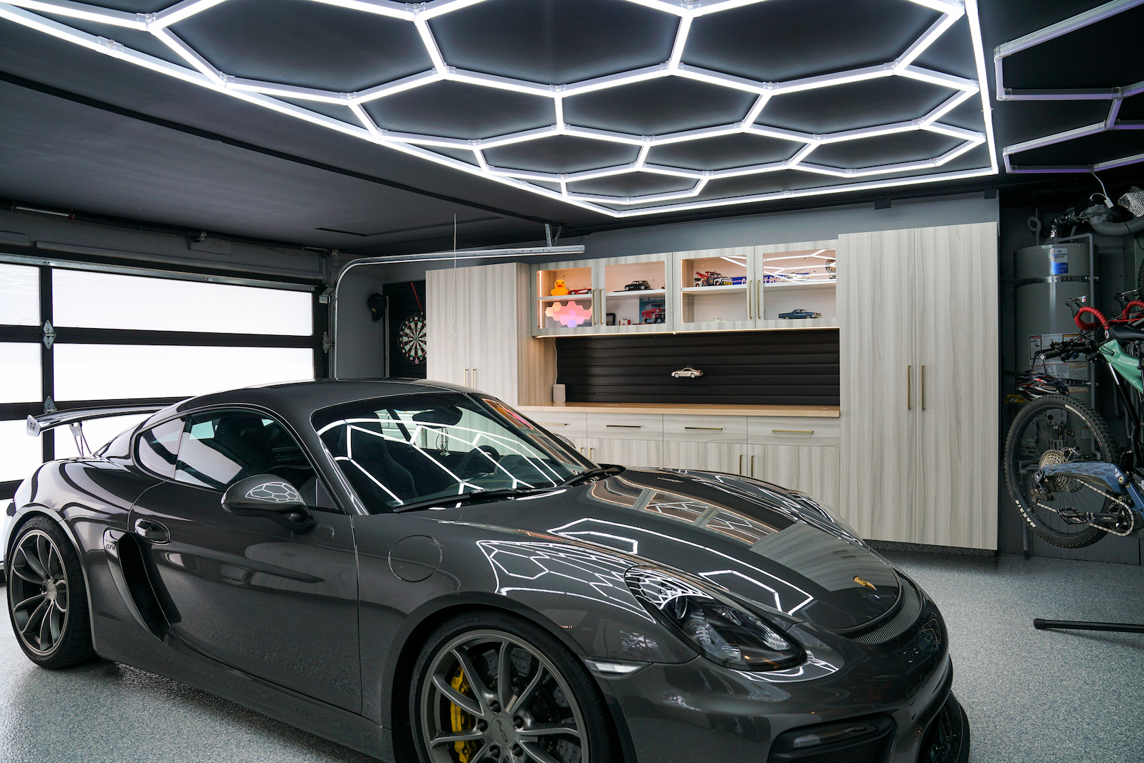 finished garage remodel with custom cabinets wall storage and hex lighting